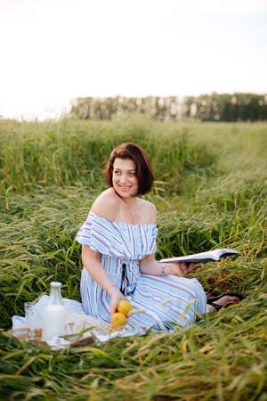 Beautiful young woman in summer in a wheat fieldの写真素材