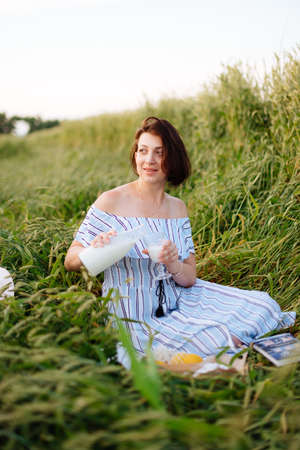 Beautiful young woman in summer in a wheat fieldの写真素材