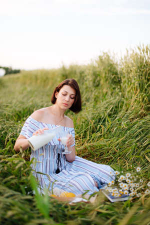 Beautiful young woman in summer in a wheat fieldの写真素材