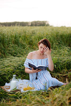 Beautiful young woman in summer in a wheat fieldの写真素材