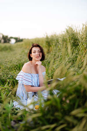 Beautiful young woman in summer in a wheat fieldの写真素材