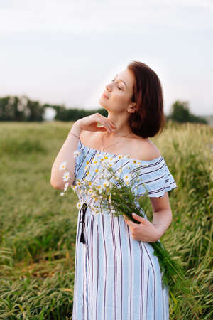 Beautiful young woman in summer in a wheat fieldの写真素材