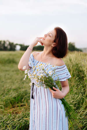 Beautiful young woman in summer in a wheat fieldの写真素材