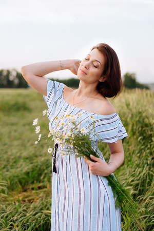 Beautiful young woman in summer in a wheat fieldの写真素材