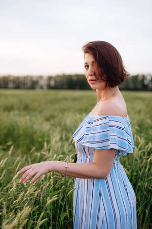 Beautiful young woman in summer in a wheat fieldの写真素材