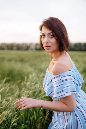 Beautiful young woman in summer in a wheat fieldの写真素材