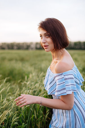 Beautiful young woman in summer in a wheat fieldの写真素材