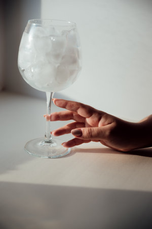 A woman's hand holds a glass with iceの写真素材