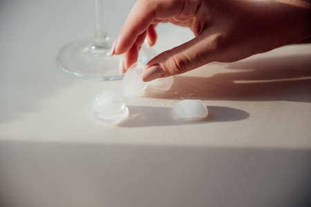 A woman's hand holds a glass with iceの写真素材