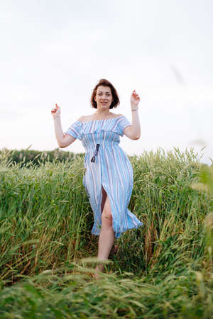 Beautiful young woman in summer in a wheat fieldの写真素材