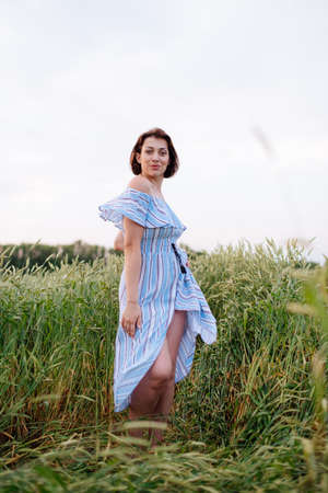 Beautiful young woman in summer in a wheat fieldの写真素材