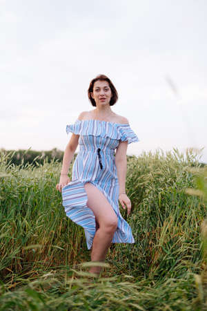 Beautiful young woman in summer in a wheat fieldの写真素材