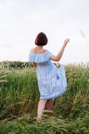 Beautiful young woman in summer in a wheat fieldの写真素材