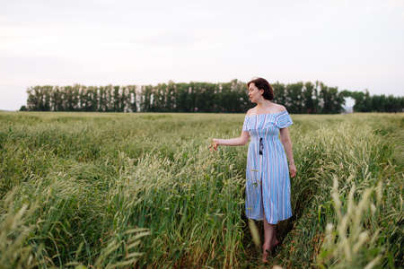 Beautiful young woman in summer in a wheat fieldの写真素材