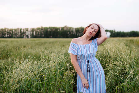 Beautiful young woman in summer in a wheat fieldの写真素材
