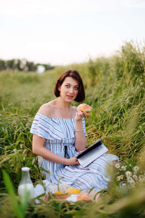 Beautiful young woman in summer in a wheat fieldの写真素材