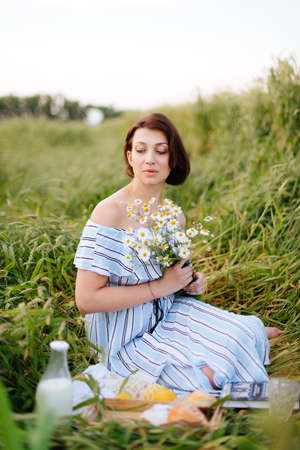 Beautiful young woman in summer in a wheat fieldの写真素材