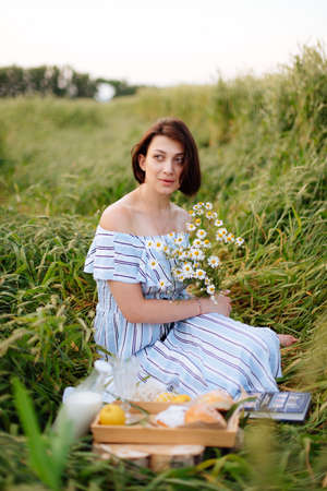 Beautiful young woman in summer in a wheat fieldの写真素材
