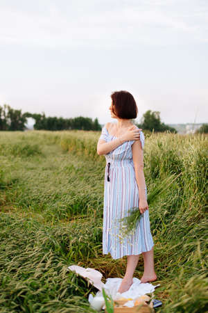 Beautiful young woman in summer in a wheat fieldの写真素材