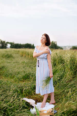 Beautiful young woman in summer in a wheat fieldの写真素材