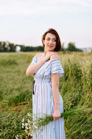Beautiful young woman in summer in a wheat fieldの写真素材