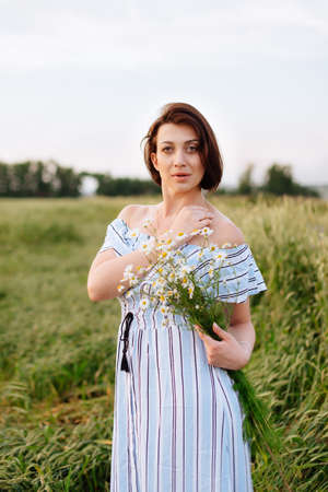 Beautiful young woman in summer in a wheat fieldの写真素材