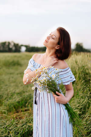 Beautiful young woman in summer in a wheat fieldの写真素材