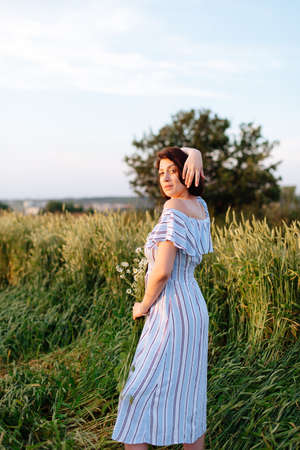 Beautiful young woman in summer in a wheat fieldの写真素材
