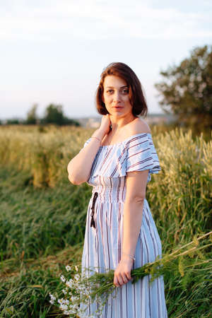 Beautiful young woman in summer in a wheat fieldの写真素材