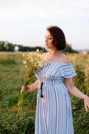 Beautiful young woman in summer in a wheat fieldの写真素材