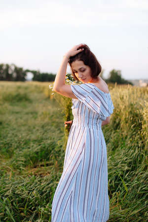 Beautiful young woman in summer in a wheat fieldの写真素材