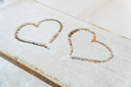 A heart drawn with a finger on the snowの写真素材