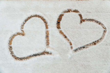 A heart drawn with a finger on the snowの写真素材