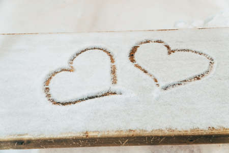 A heart drawn with a finger on the snowの写真素材