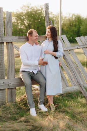 Young heterosexual pregnant couple in an outdoor parkの写真素材