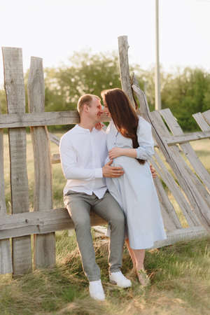 Young heterosexual pregnant couple in an outdoor parkの写真素材