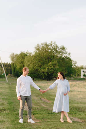 Young heterosexual pregnant couple in an outdoor parkの写真素材