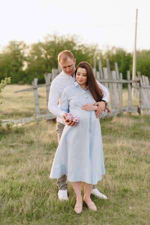 Young heterosexual pregnant couple in an outdoor parkの写真素材