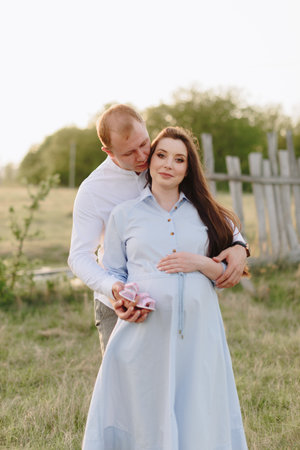 Young heterosexual pregnant couple in an outdoor parkの写真素材