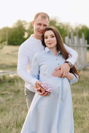 Young heterosexual pregnant couple in an outdoor parkの写真素材