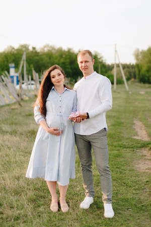 Young heterosexual pregnant couple in an outdoor parkの写真素材