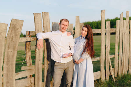 Young heterosexual pregnant couple in an outdoor parkの写真素材