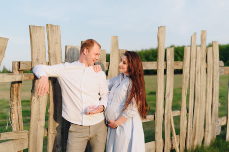 Young heterosexual pregnant couple in an outdoor parkの写真素材