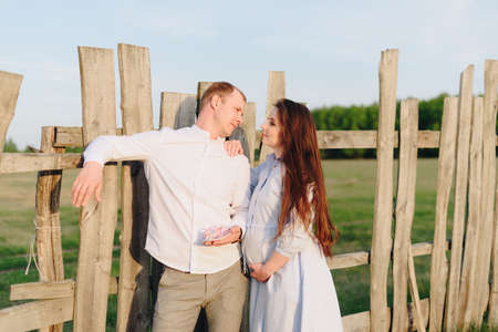 Young heterosexual pregnant couple in an outdoor parkの写真素材