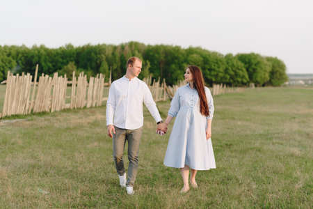Young heterosexual pregnant couple in an outdoor parkの写真素材