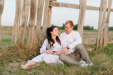 Young heterosexual pregnant couple in an outdoor parkの写真素材