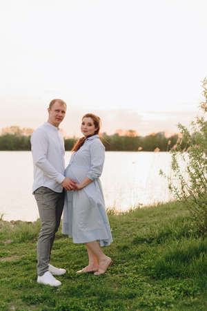 Young heterosexual pregnant couple in an outdoor parkの写真素材