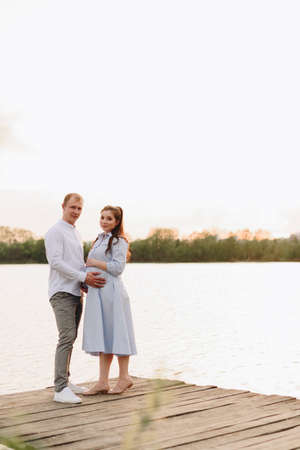 Young heterosexual pregnant couple in an outdoor parkの写真素材
