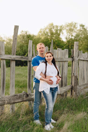 Young heterosexual pregnant couple in an outdoor parkの写真素材