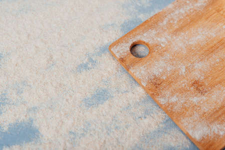 part of a cutting wooden board on a blue background with flour 1の写真素材